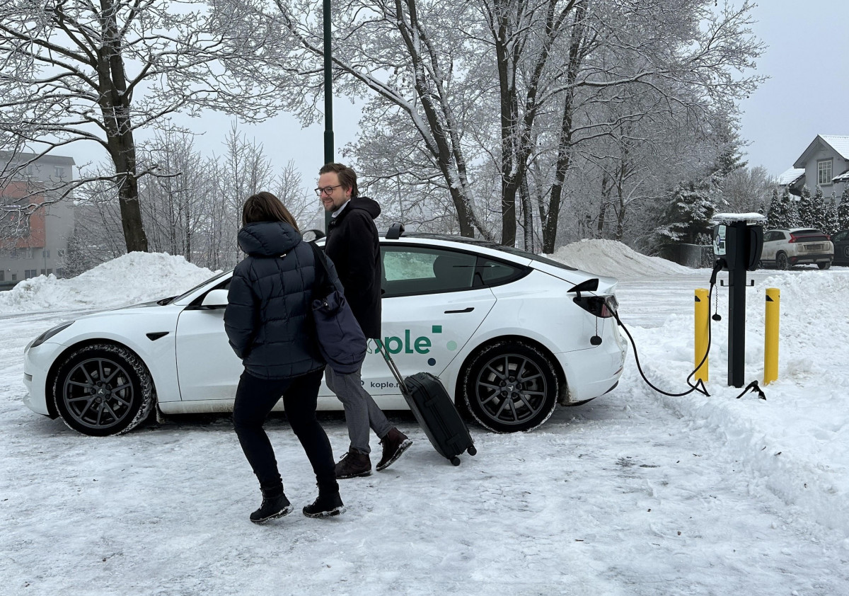 To personer på vei bort fra ladene elbil.